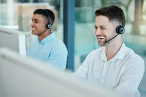 happy call center consultant man laugh on customer service phone call and happiness in office